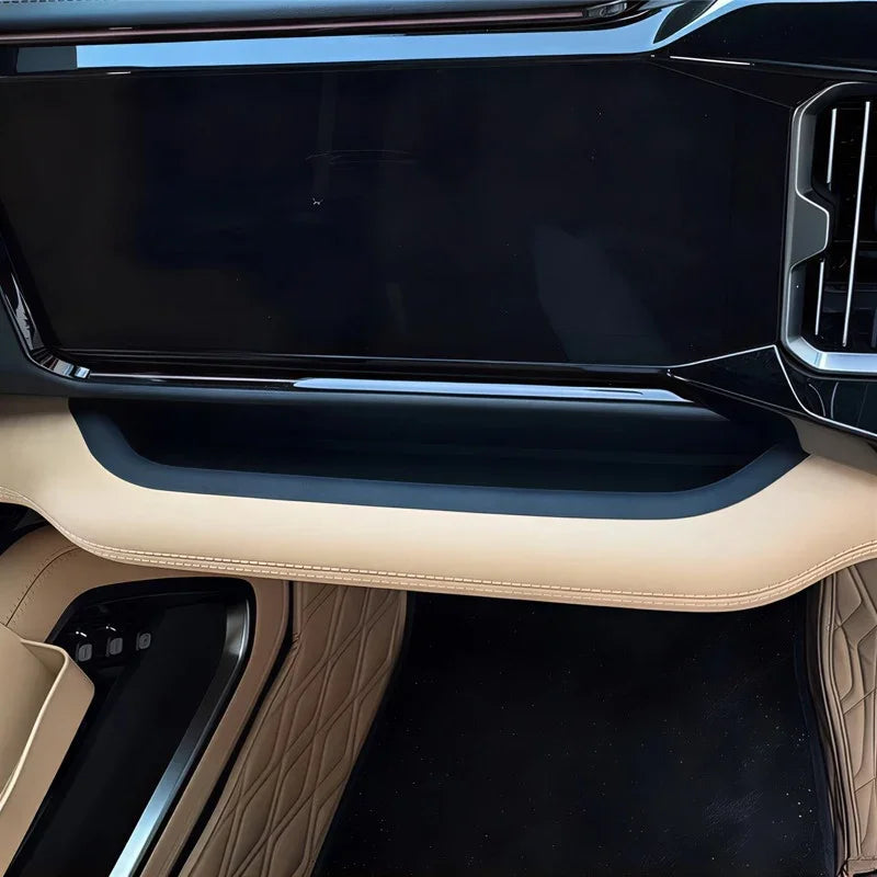 Black glossy dashboard panel with beige leather trim and quilted tan interior accents.