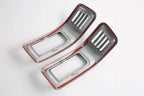 Pair of grey carbon fiber texture interior trim pieces with vibrant red accent borders.