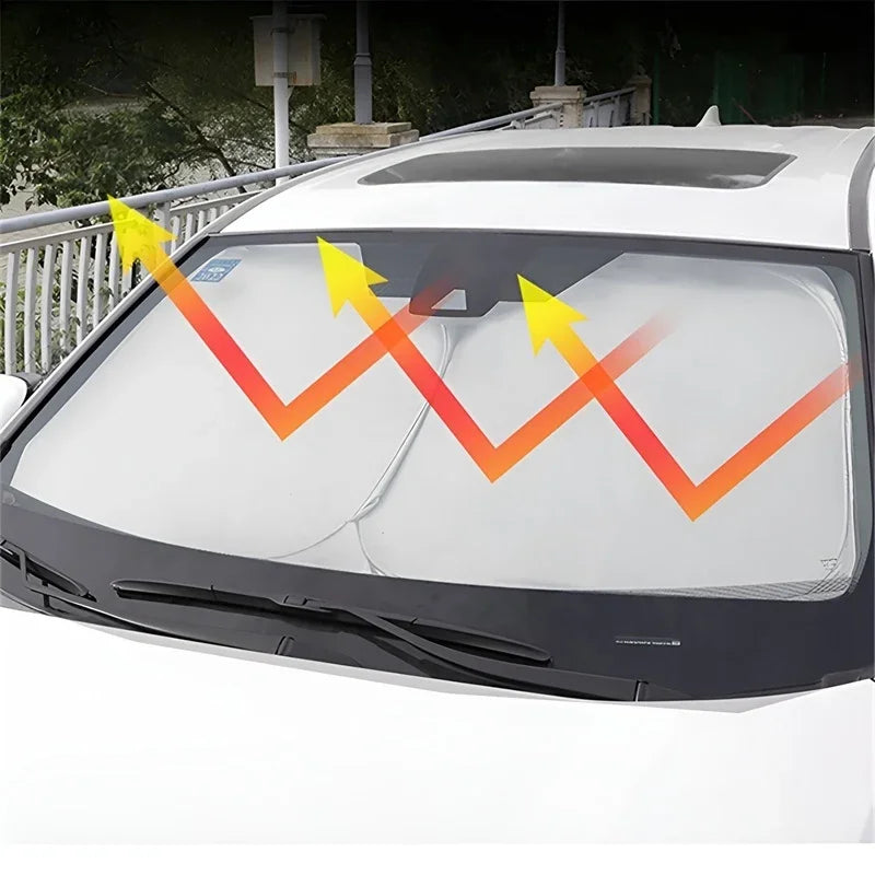 White car windshield with silver heat-reflective sunshade blocking solar rays.