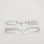 Silver metallic BYD car emblems in transparent plastic protective packaging.