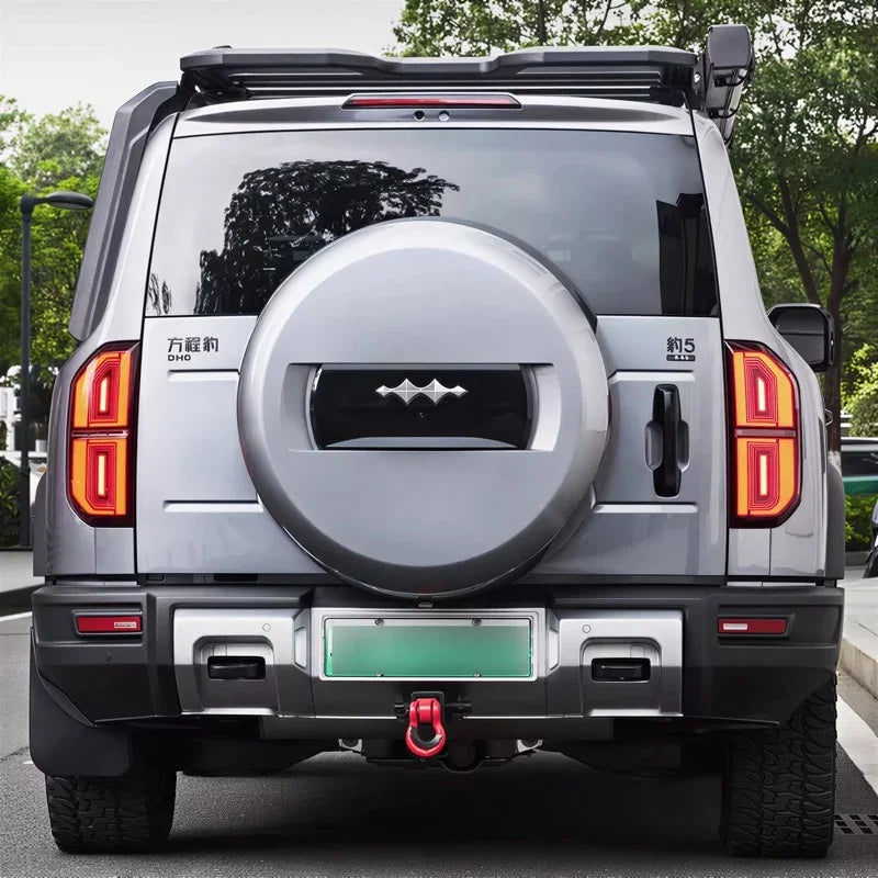 Rear view of a silver BYD Fangchengbao hard-shell spare tire cover and rugged SUV exterior.