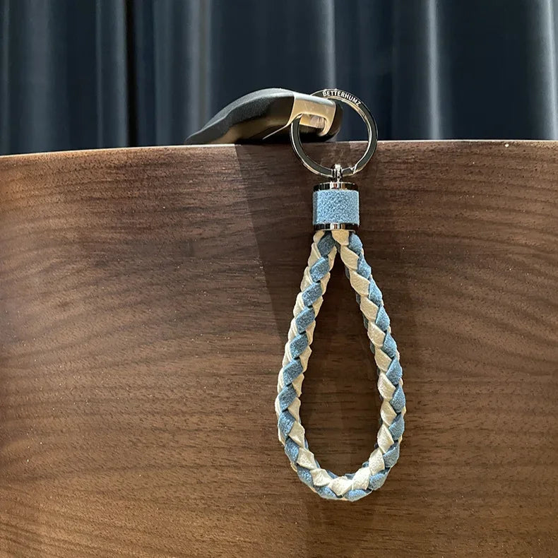 Braided blue and beige leather keychain with a durable silver metal ring.