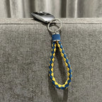 Braided blue and yellow fabric keychain loop attached to a silver car key fob.