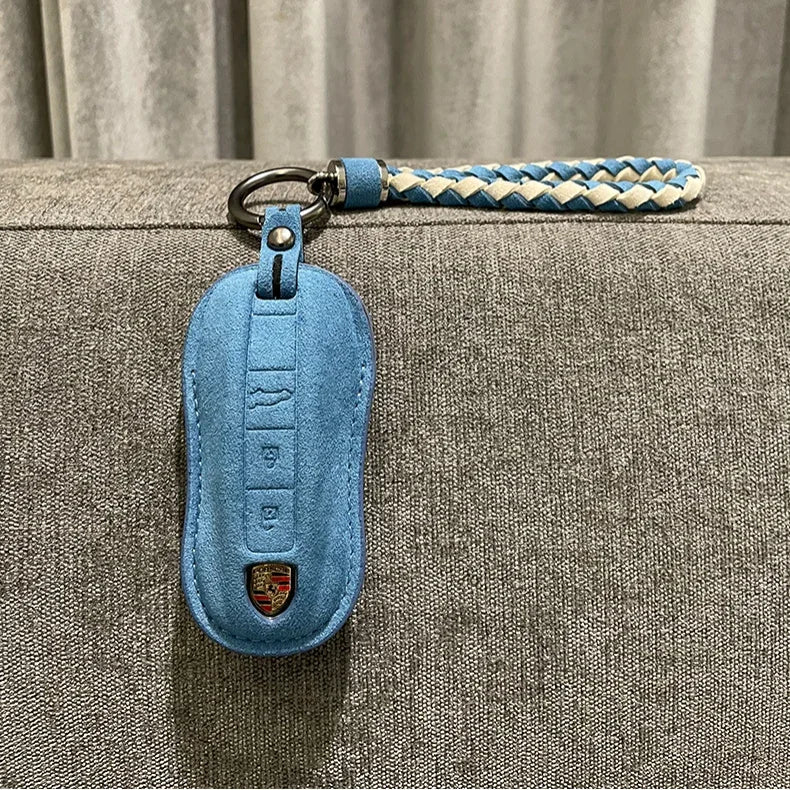 Light blue suede car key fob cover with a matching braided blue and white leather strap.