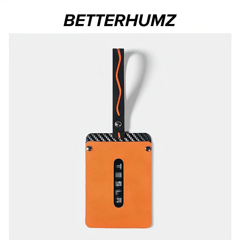Orange leather car key fob with black carbon fiber trim and decorative stitching.