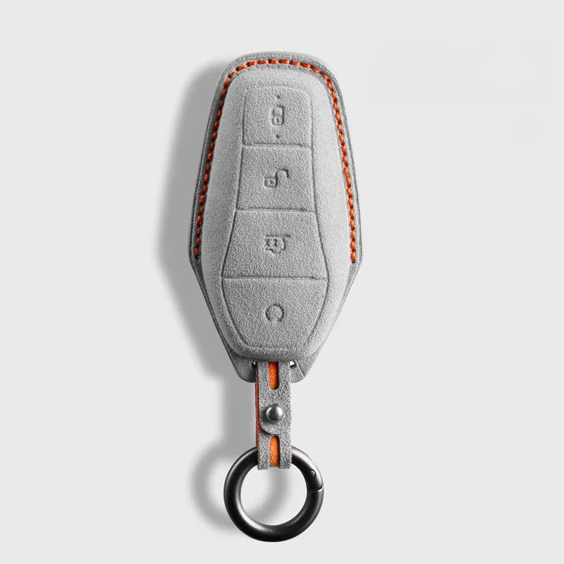 Grey suede car key fob cover with distinctive orange contrast stitching.