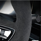 Black perforated suede-texture steering wheel cover for enhanced grip and comfort.