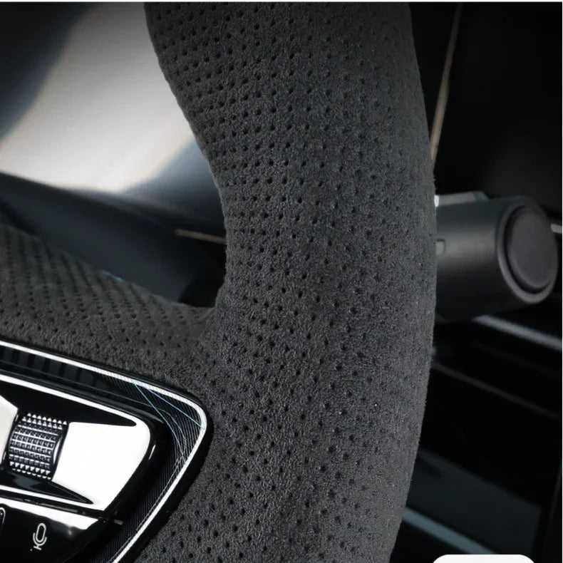 Black perforated suede-texture steering wheel cover for enhanced grip and comfort.