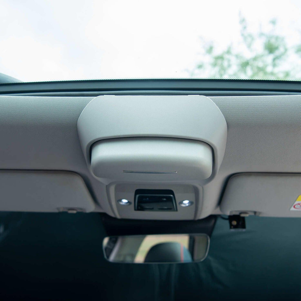 Grey interior overhead console with integrated light and control buttons in a car ceiling.