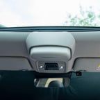Grey interior overhead console with integrated light and control buttons in a car ceiling.