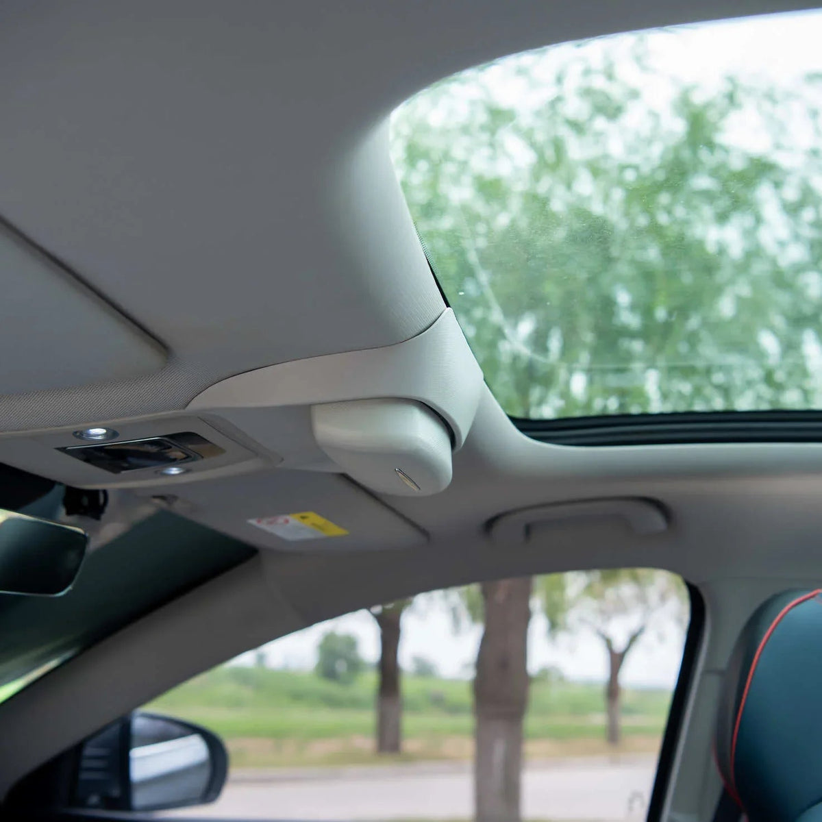 Light beige premium interior ceiling featuring a large panoramic sunroof and integrated sun visor.