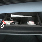 Black felt-lined car organizer tray with compartments containing personal items.