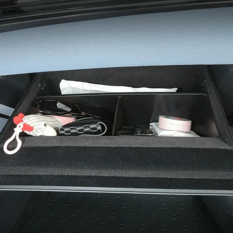 Black felt-lined car organizer tray with compartments containing personal items.
