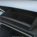 Black textured synthetic material center console organizer tray for car interior.