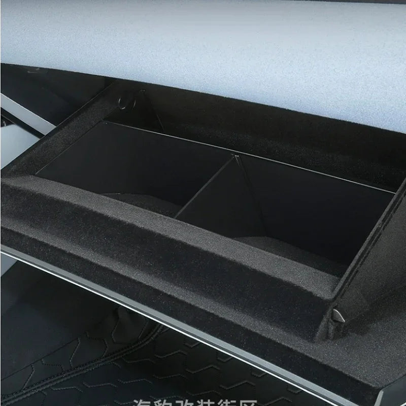 Black textured synthetic material center console organizer tray for car interior.