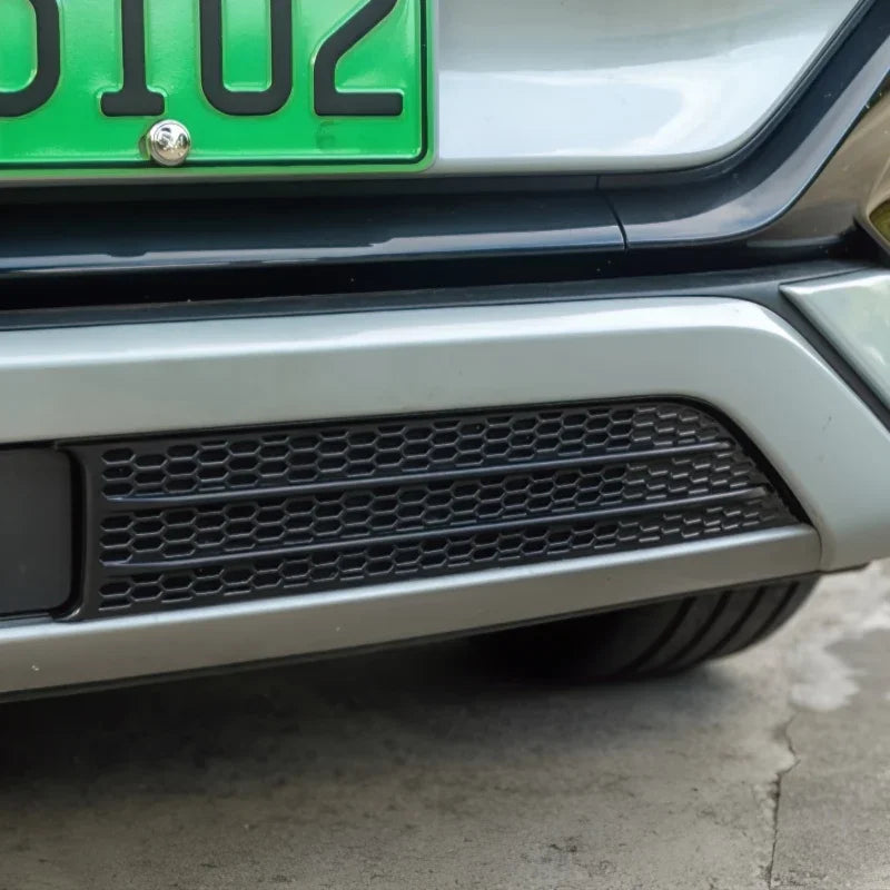Silver rear bumper with a black honeycomb pattern grille for a modern vehicle