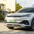 Front view of a sleek silver electric vehicle with a green license plate.