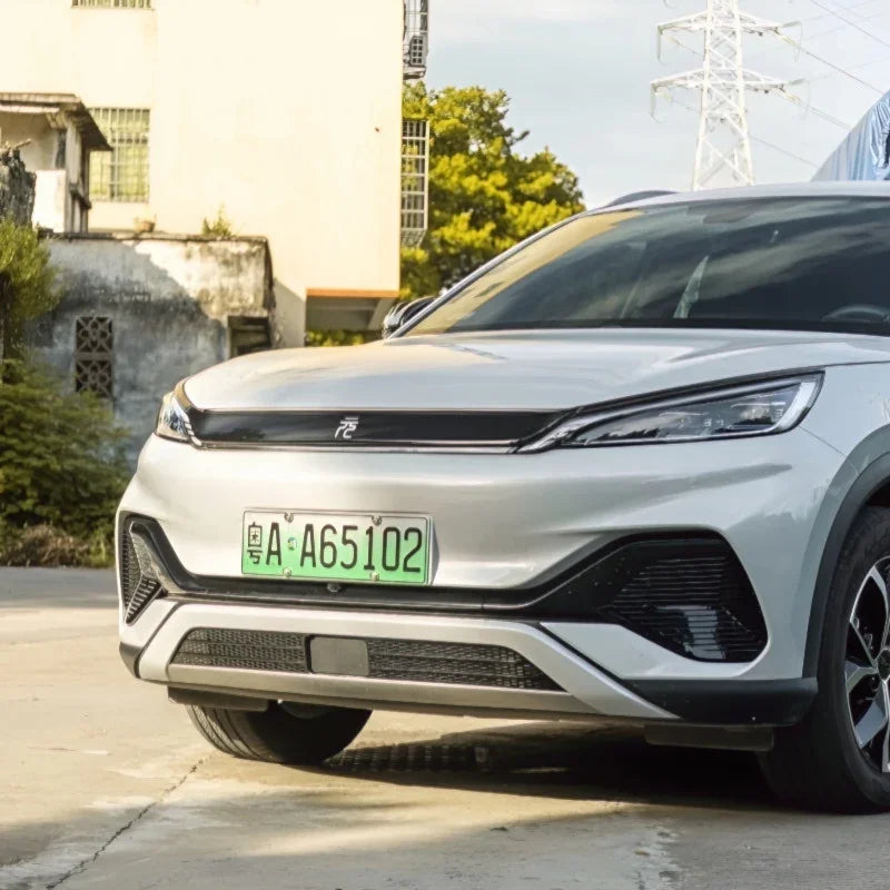 Front view of a sleek silver electric vehicle with a green license plate.