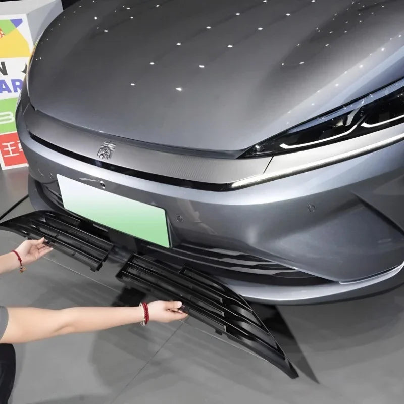 Professional installation of a durable black matte front lip spoiler on a grey sedan.