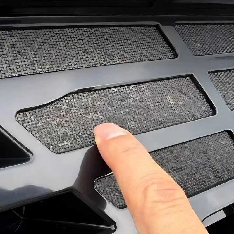 Close-up of a black gloss automotive grille featuring a durable mesh material.