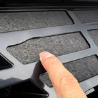Close-up of a black gloss automotive grille featuring a durable mesh material.