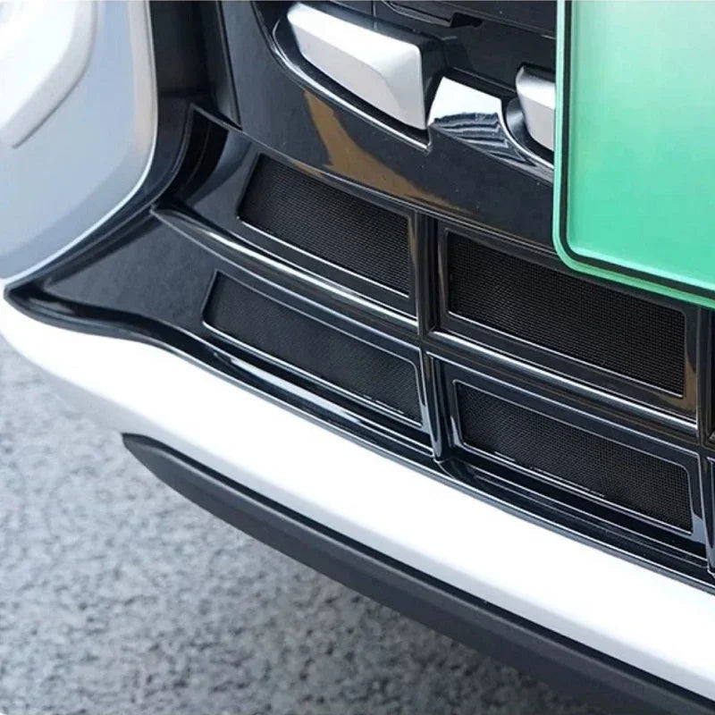 Glossy black front bumper grille with fine mesh texture for BYD vehicle protection.