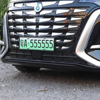 Close-up of a black BYD vehicle front grille featuring chrome accents and a green license plate.
