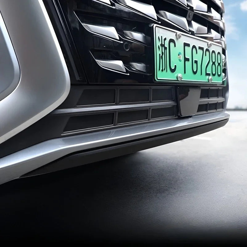 Black glossy front bumper grille with silver metallic trim accents on a vehicle.