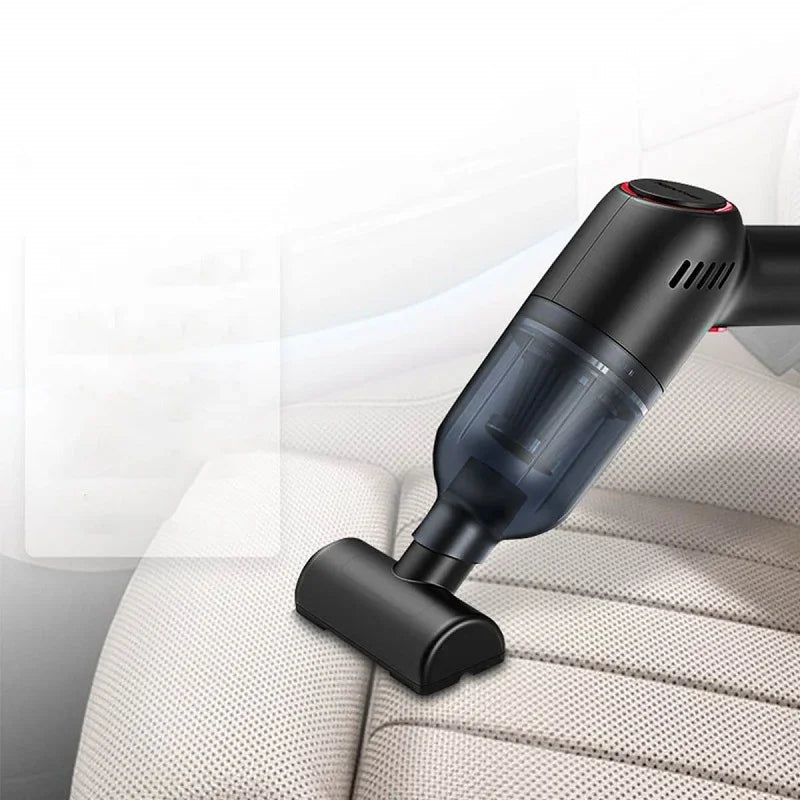 Black handheld cordless car vacuum cleaner cleaning light beige perforated leather seats.