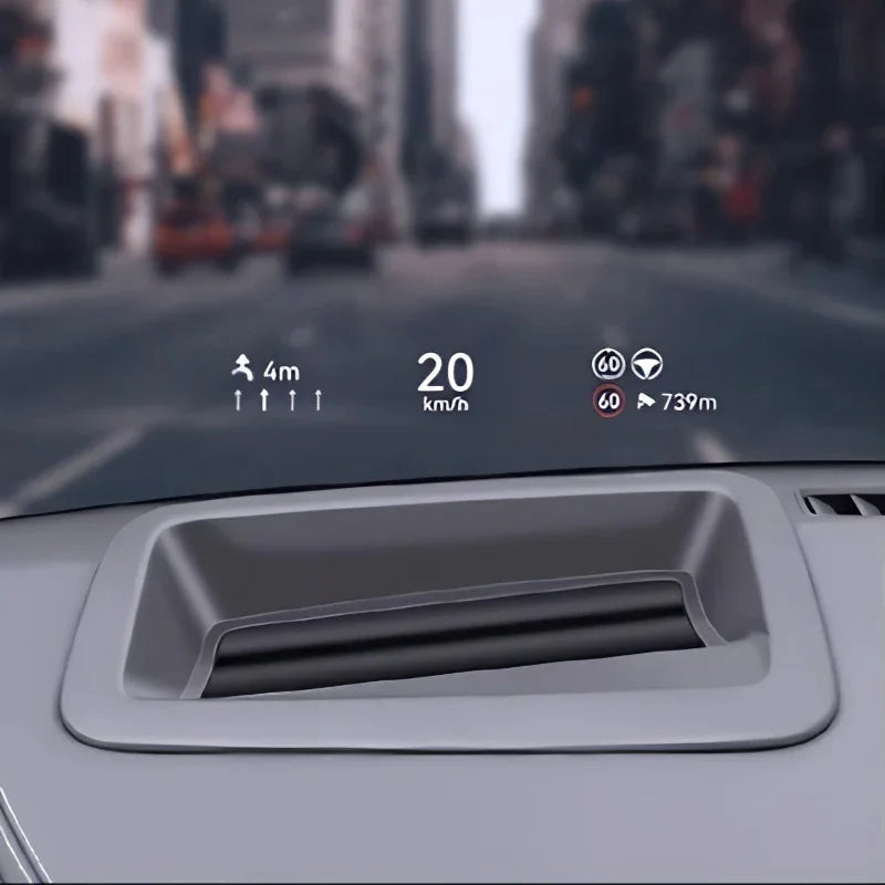 Grey dashboard air vent with digital HUD display showing speed and distance on a city road.