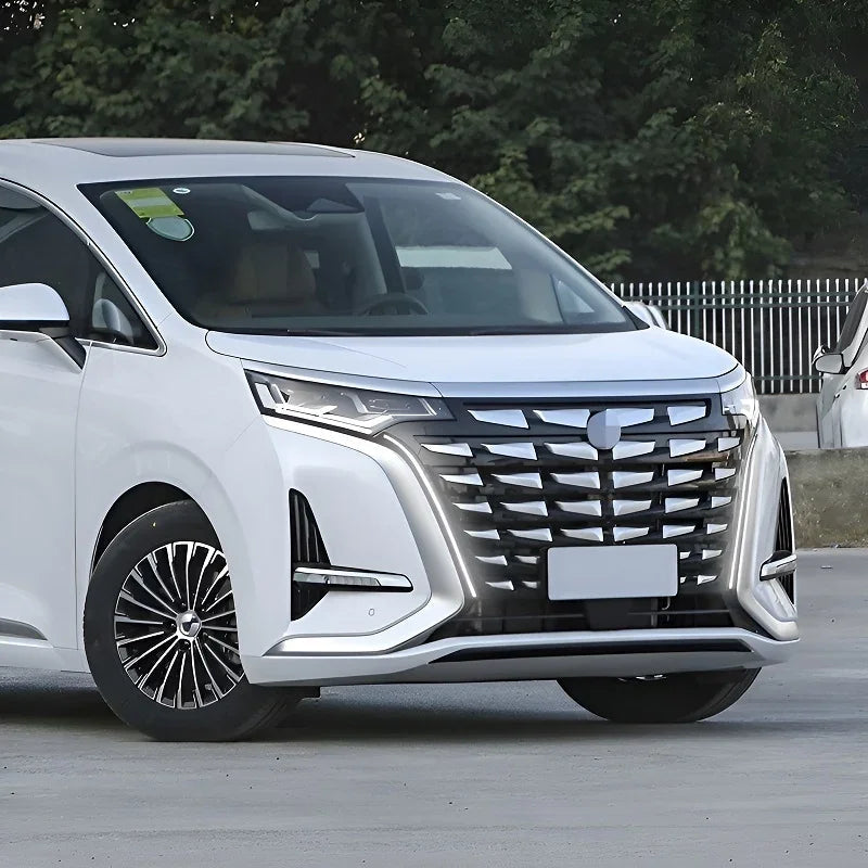 Front view of a white BYD MPV with a large black chrome grille and sleek LED headlights.