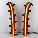 Pair of black plastic automotive LED light strips with glowing orange illumination.