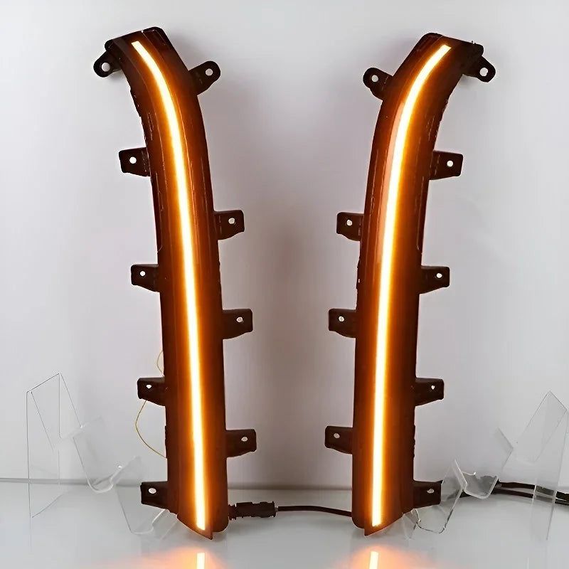 Pair of black plastic automotive LED light strips with glowing orange illumination.
