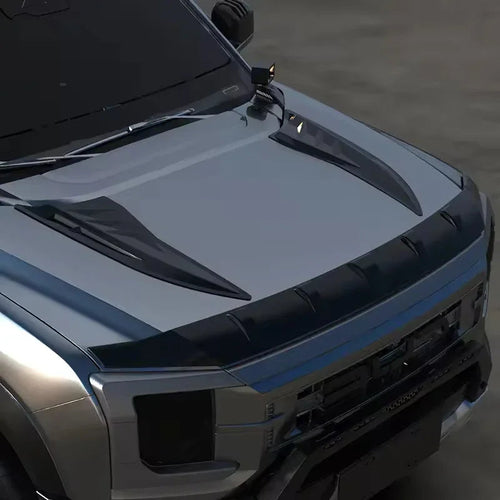 Sleek black carbon fiber hood scoop and aerodynamic deflector on a silver SUV.
