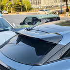 Sleek black aerodynamic rear spoiler installed on a grey car trunk for enhanced styling.