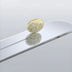 Gold coin balanced on a sleek, silver reflective surface showcasing a mirrored finish.