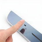 Finger pressing the power button on a sleek, blue metallic tempered glass car accessory panel.