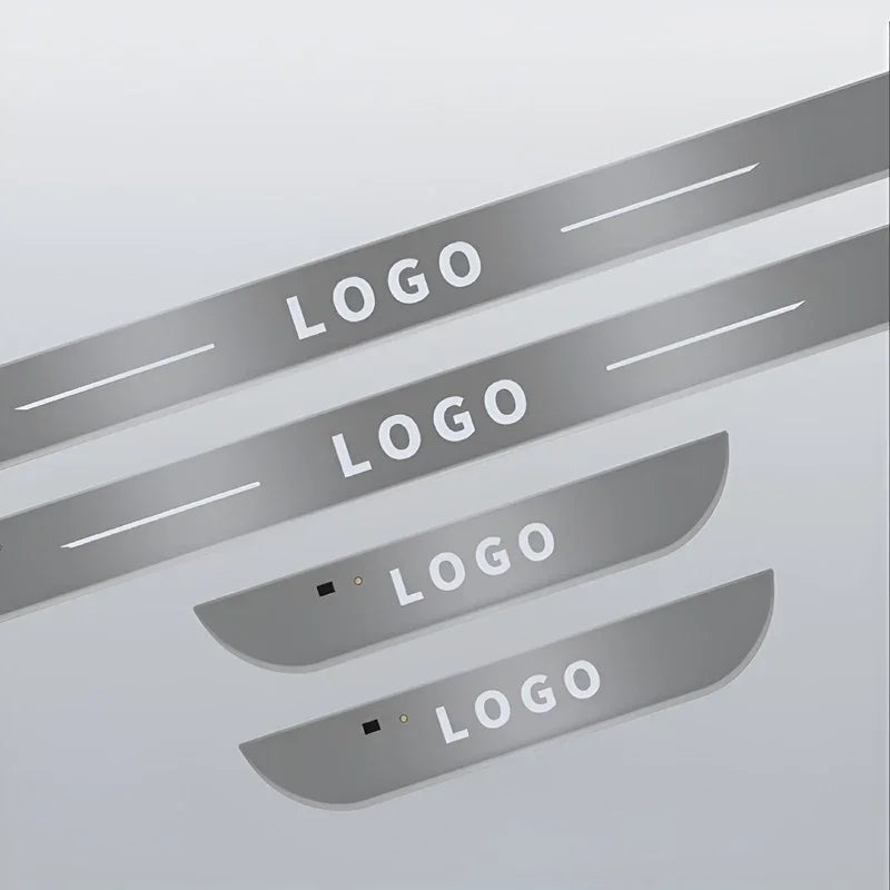 Set of silver metallic door sill protectors with custom logo engraving for car protection.