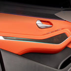 Luxury orange leather car door panel with carbon fiber accents and ambient lighting