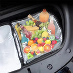 A durable silver waterproof trunk organizer filled with fresh fruits and beverages in a car trunk.