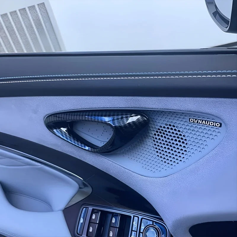 Premium carbon fiber texture tweeter cover on a grey leather car door panel with Dynaudio speaker.