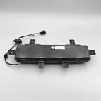 Black durable plastic trunk liner component with integrated wiring and connector.