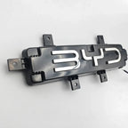Black plastic BYD emblem badge with polished chrome lettering for car exterior decoration.