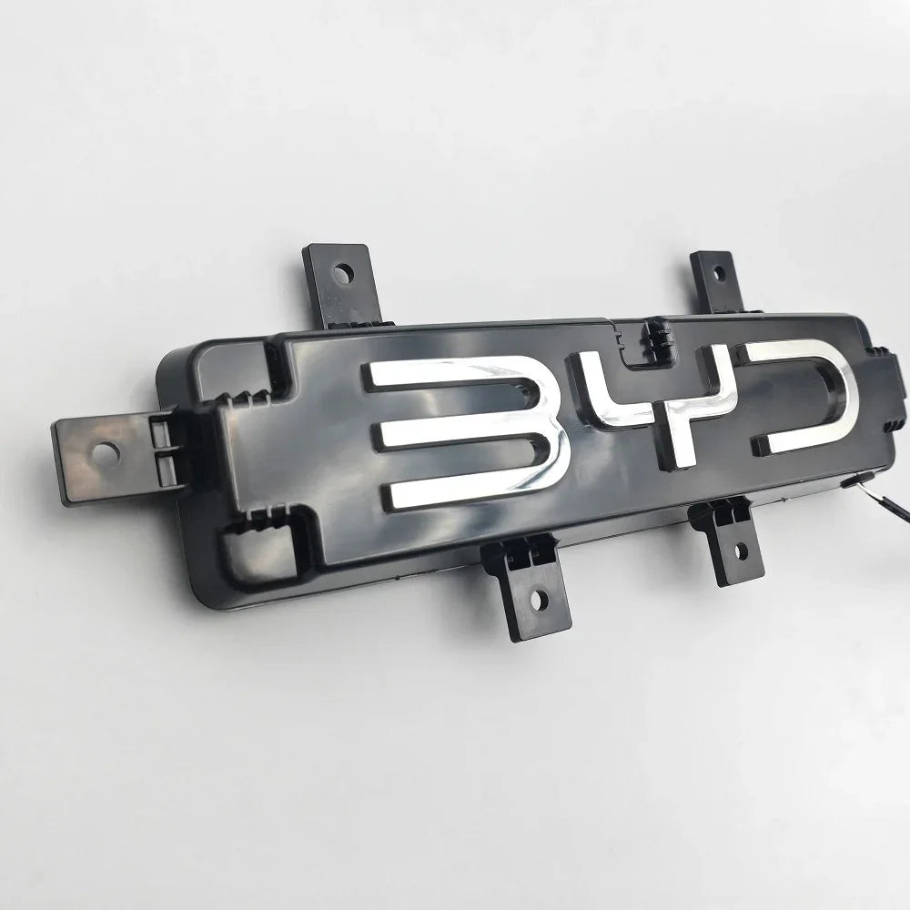 Black plastic BYD emblem badge with polished chrome lettering for car exterior decoration.