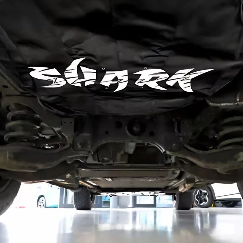 Black Shark protective underbody cover for car chassis, featuring durable fabric material.