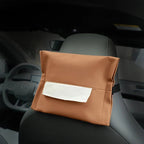 Brown faux leather car seat organizer with a clear pocket attached to a grey car headrest.