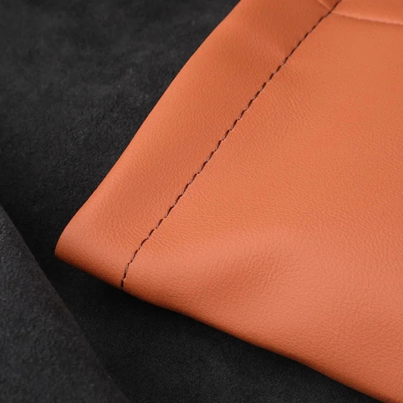 Close-up of brown faux leather car accessory featuring precise stitching and soft texture.