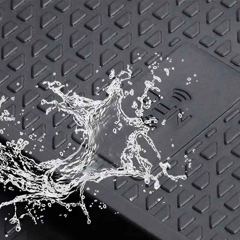 Water splashing on a black waterproof textured car mat made of durable synthetic material.