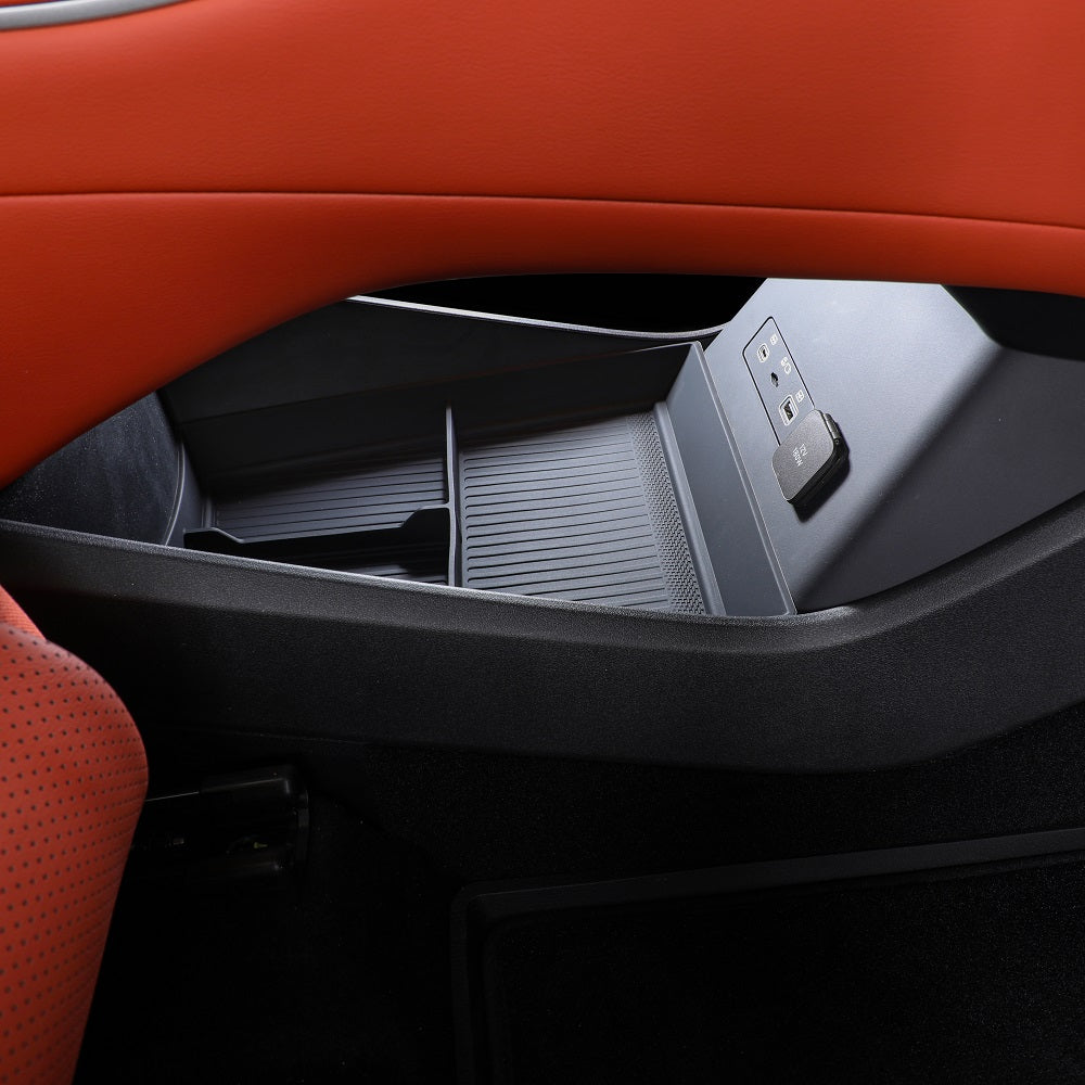 Black textured plastic interior storage tray with USB ports integrated into a BYD car console.