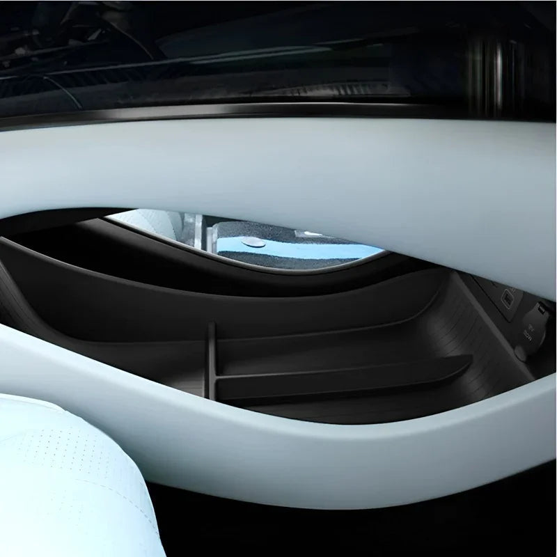 Close-up of a light blue car interior glove box with a sleek black plastic divider.